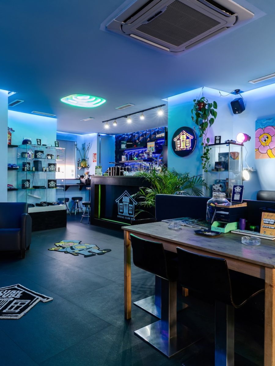 The main room at Kush House Social Club in Barcelona, with lounge seating, artwork and blue lighting.